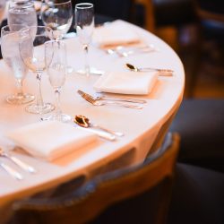 Elegancko nakryty stół z kieliszkami i białymi serwetkami w restauracji fine dining.